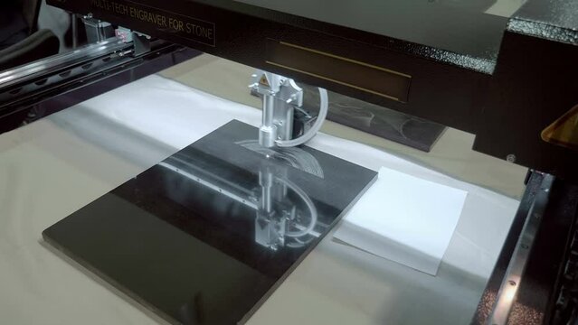 Stone laser engraving equipment, puts an image on a granite slab. Shot in motion