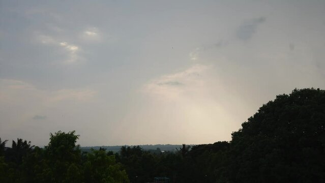 timelaps sunset behind tree cloudes rainy day  India Maharashtra Karnataka south India  rays shine