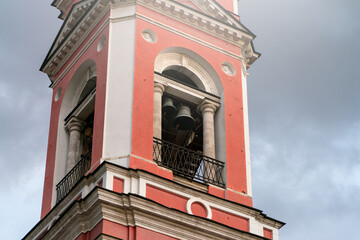The bell tower of a Christian church against a gray sky. A religious temple.