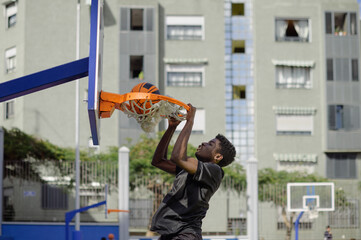 Black man performing slam dunk while playing basketball © Gabriel Trujillo