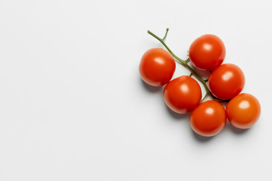 Top view of whole fresh cherry tomatoes on white background.