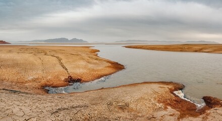 The shore of the Krasnoyarsk reservoir without water, sandy ripples, clay and hills, rainy sky over Mount Tepsey Tepsei