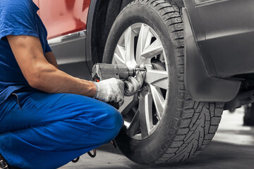 Concept car wheel service. Professional mechanic changing tires