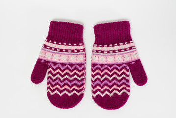 A pair of pink knitted mittens isolated on a white background.