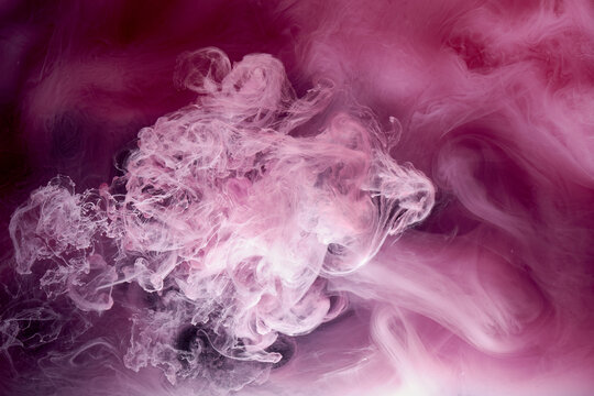 Pink gray smoke on black ink background, colorful fog, abstract swirling touch ocean sea, acrylic paint pigment underwater