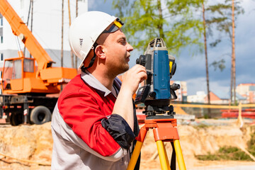 Construction of a residential area. Geodetic stakeout. Surveyor at a large construction site. A man with a tachometer during work. Makshader.
