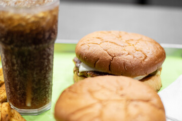 A picture of burger, fries and coke with ice in a glass from a fast food restaurant