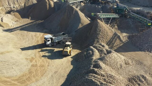 Trucks is working. Aerial view of the quarry in the beautiful majestic landscape
