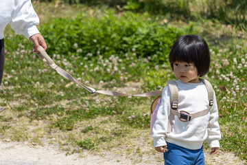 迷子紐をつけられて落ち込む赤ちゃん（1歳10か月、女の子、日本人）