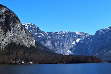 Alpine mountain lake on a cloudless day in winter. Lack of snowfall in the alps from climate change example (Lake Hallstatt, Austria)