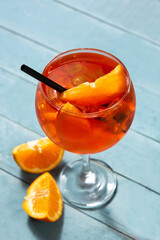 Glass of aperol spritz cocktail on blue wooden table - obrazy, fototapety, plakaty