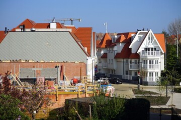 Blick von der Dachterrasse eines Ferienhaus auf eine Baustelle und neue weiße Nachbarhäuser vor...