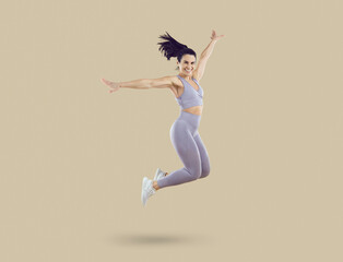Happy excited cheerful joyful beautiful fit young woman in lilac crop top and leggings smiling and...