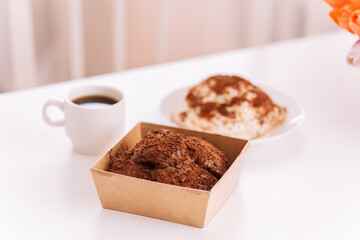 Two cakes with cup of coffee on white table.