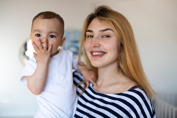 Mom and her son in the nursery. Mom holds her son in her arms. Motherhood. Mom and her son play together. Happy Mother's Day!