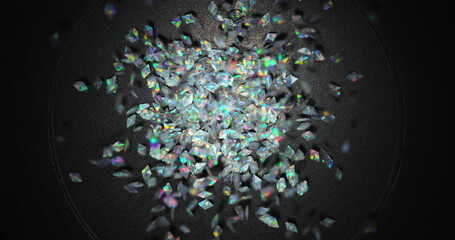 Small colorful particles shaking against dark background