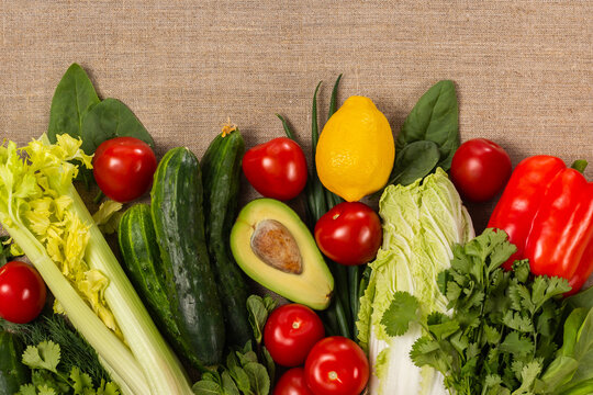 Different vegetables on burlap background and copy space. Healthy vegetarian eating concept.