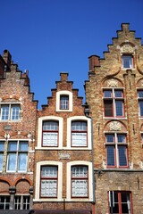 Schöne alte Häuser mit Treppengiebel und Fassaden aus rotbraunem Backstein vor blauem Himmel im...