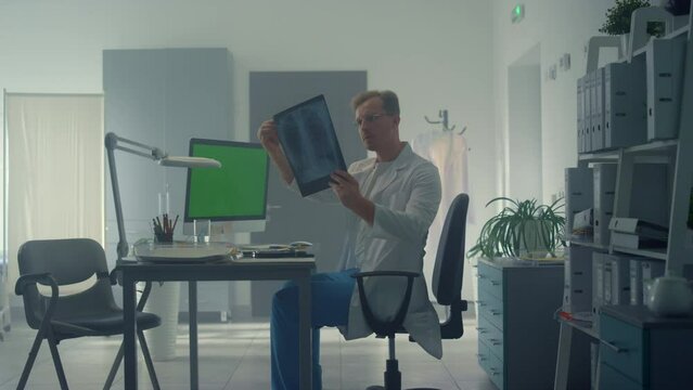 Doctor consulting online using mockup computer in clinic. Man working remotely.