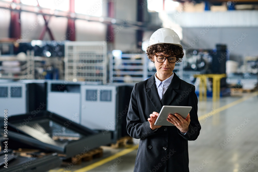 Poster young confident female engineer looking through online technical data about production of solar pane