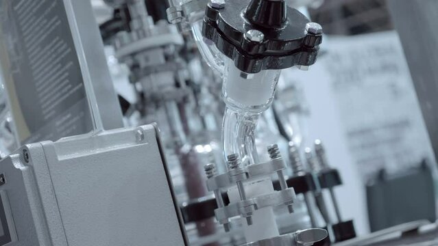 The operation of a complex and expensive chemical reactor in a laboratory for production for products in the medical, chemical, cosmetic industries. Closeup. Shot in motion