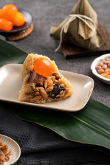 Zongzi, rice dumpling for Dragon Boat Festival on dark gray table background with ingredient. - obrazy, fototapety, plakaty