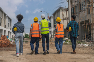 Multinational teams of male and female engineers work with a team of contractors and inspect the construction site