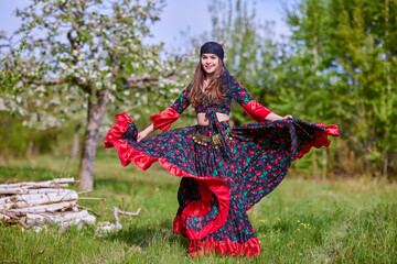 beautiful woman in traditional gypsy dress posing in nature in spring - obrazy, fototapety, plakaty