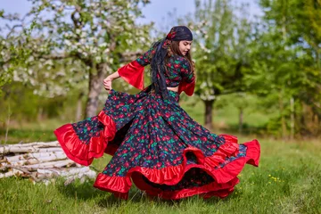 Poster beautiful woman in traditional gypsy dress posing in nature in spring © czamfir