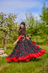 Fototapeta premium beautiful woman in traditional gypsy dress posing in nature in spring