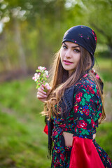 beautiful woman in traditional gypsy dress posing in nature in spring