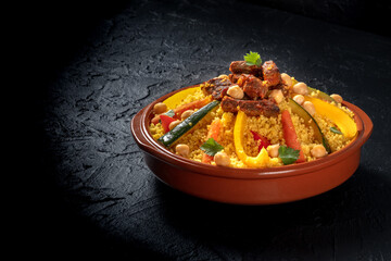 Meat and vegetable couscous, festive African food, on a dark background with a place for text