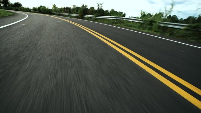Front pov view of fast car driving on asphalt road with double yellow lines converge
