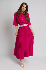 Beautiful woman in pink maxi dress and white high heels sandals.