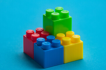 Plastic building blocks on blue background. Educational concept