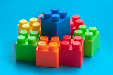 Plastic building blocks on blue background. Educational concept