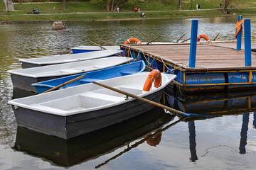   a boat with oars stands near a wooden pier © Oleg Opryshko