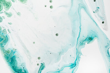 Fluid Art acrylic paints. Abstract mixing blue and green waves on white background. Liquid flows splashes. Marble effect background or texture