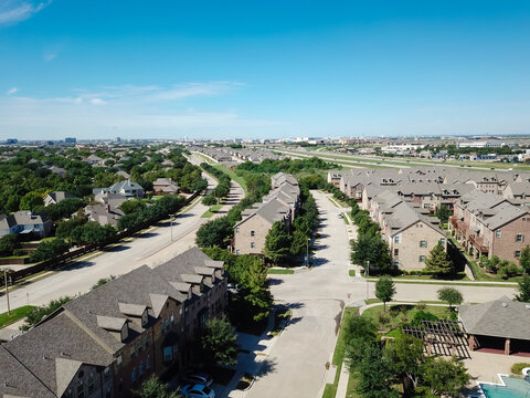 Top View Row Of New Development Three Story Townhomes Next To Single Family Residential Area With Highway In Background