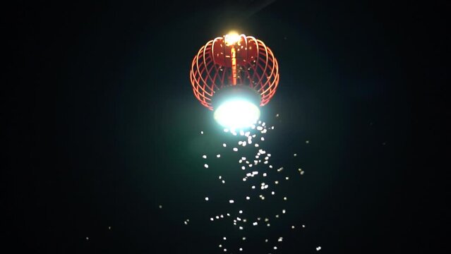 Insects, moths fly around the Chinese lantern at night. Insects fly towards the light.