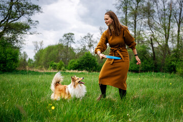 Pet parent launches a flying disc in a green field.