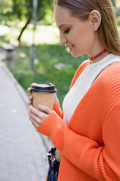 Side View Of Happy Woman Holding Paper Cup With Coffee To Go.