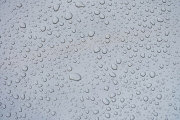 Closeup of raindrops on gray window glass texture background