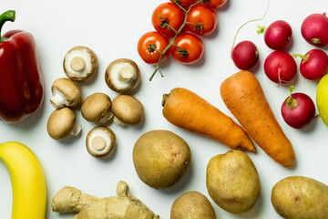 Top view of organic fruits and vegetables on white background.