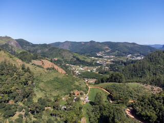 valley with mountains, coffee plantation and eucalyptus in beautiful green - aerial drone view - city from the interior