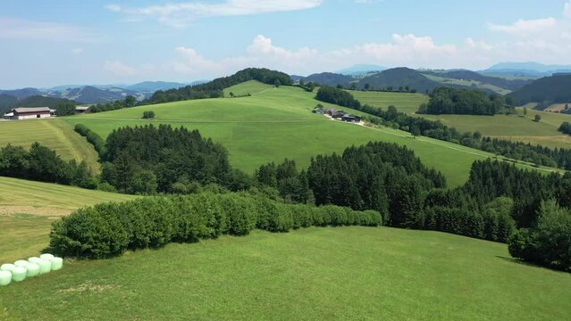 Beautiful drone view of the landscape of the plains near the city of Lienz, Austria. Alpine mountains, clouds and sunlight over the city. Aerial view of Austrian city and fields of wheat and rye