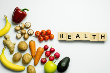 Top view of wooden cubes with health lettering near food on white background.