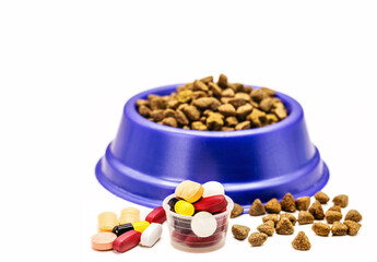 veterinary pills or medication, supplements or vitamins for pets, with pet food in the background, with copyspace