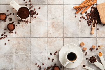 Coffee background. Measuring spoons with ground coffee, beans, cup and sweet chocolate truffles on old tile cracked table background. Food background. Top view with space for your text