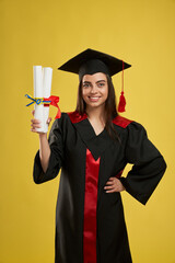 Front view of pretty female graduate standing, holding two diplomas. Student with bachelor, master...